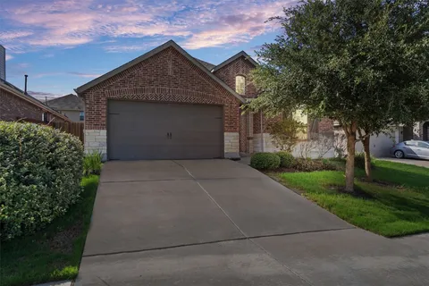 a front view of a house with yard and garage
