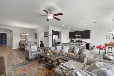 a living room with furniture kitchen view and a potted plant