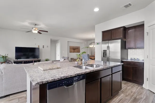 a kitchen with granite countertop a sink appliances and cabinets