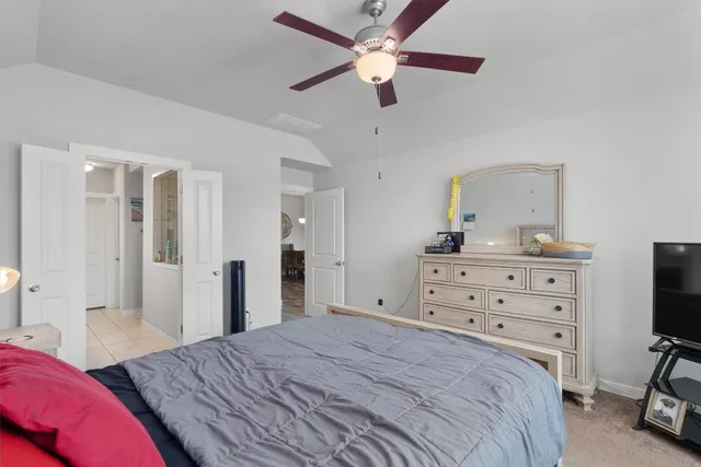 a bedroom with a bed and a flat tv screen on dresser