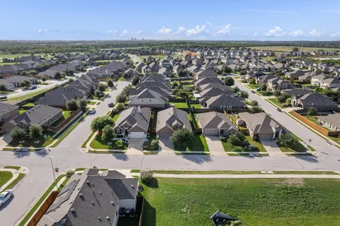 an aerial view of residential houses with outdoor space and ocean view