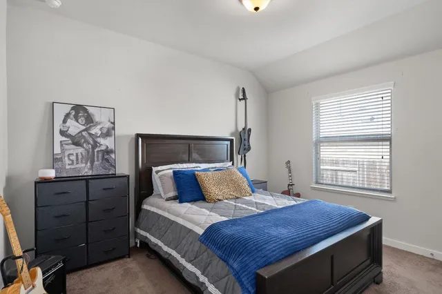 a bedroom with a bed and painting on the wall