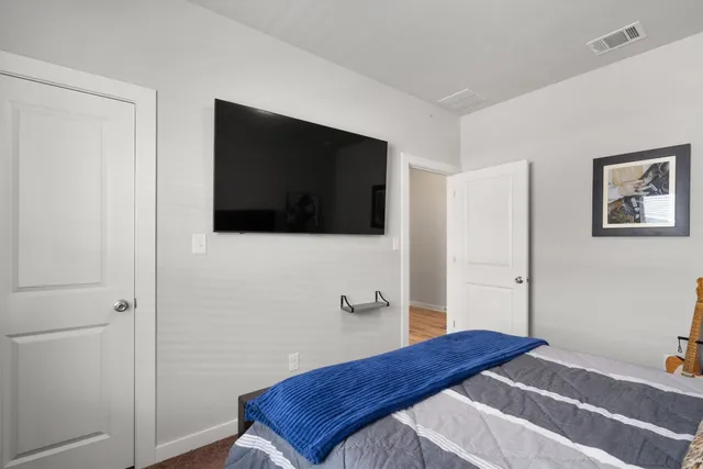 a bedroom with a bed and a flat screen tv