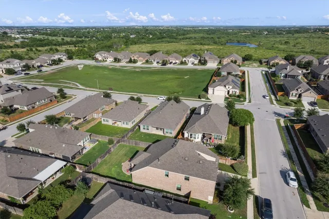 an aerial view of a house with a garden and mountain view in back