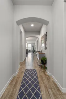 a view of a hallway with wooden floor and a potted plant