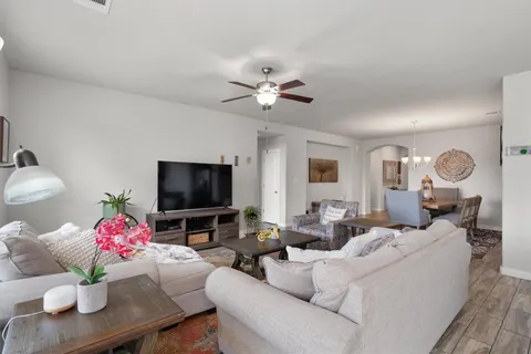 a living room with furniture a chandelier and a flat screen tv