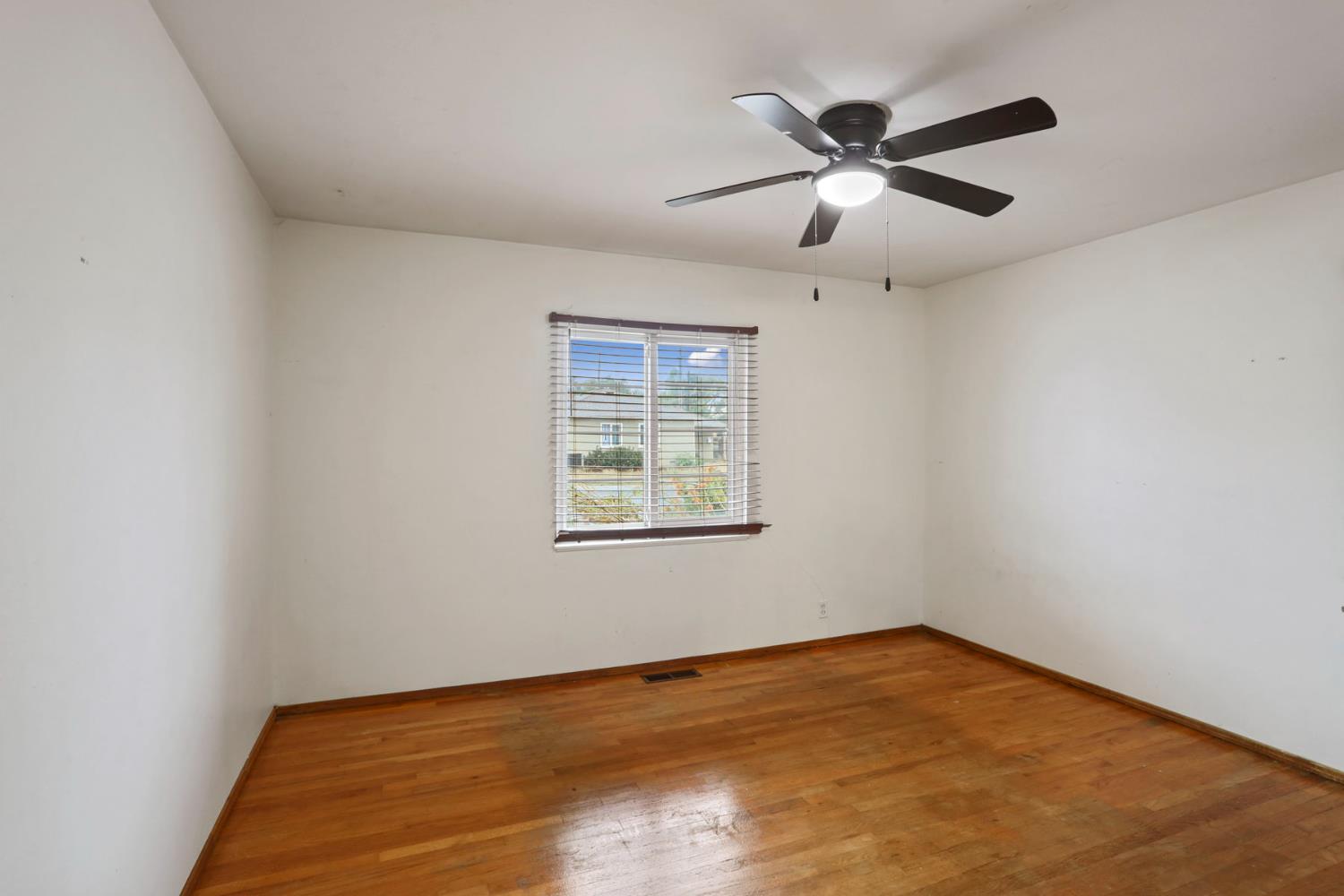 2755 Inman Avenue Stockton, CA 95204 - Photo 15 of 34 an empty room with wooden floor ceiling fan and window