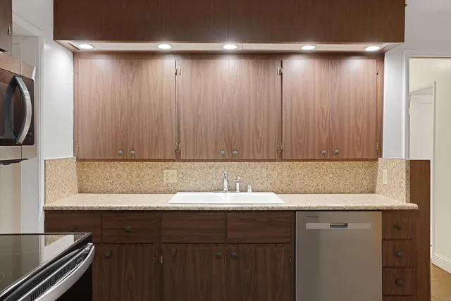 a kitchen with stainless steel appliances granite countertop a refrigerator and a stove