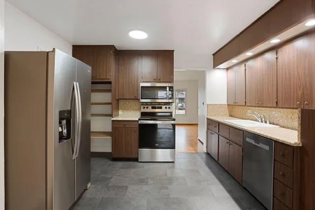 a large kitchen with cabinets and stainless steel appliances