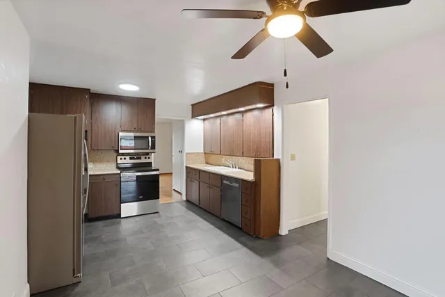 a kitchen with stainless steel appliances granite countertop a refrigerator stove and sink