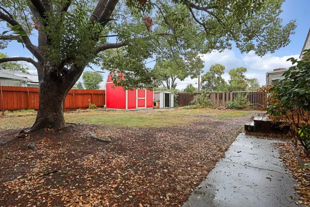 a view of a house with backyard and tree