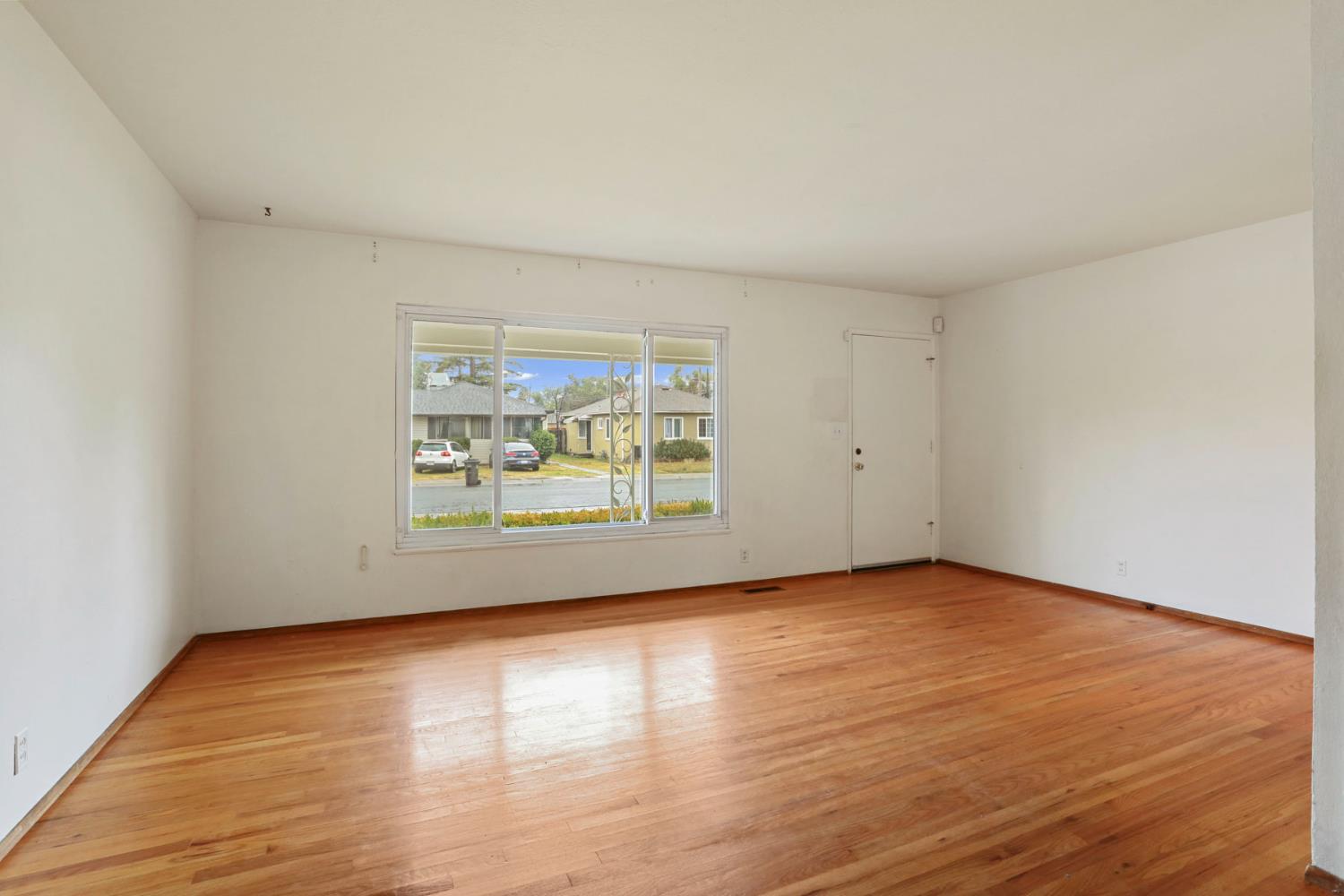 2755 Inman Avenue Stockton, CA 95204 - Photo 10 of 34 a view of an empty room with wooden floor and a window