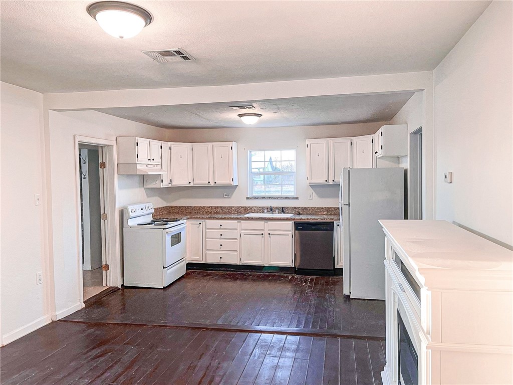 129 Illinois Avenue China Spring, TX 76633 - Photo 5 of 11 a kitchen with a white cabinets and wooden floor