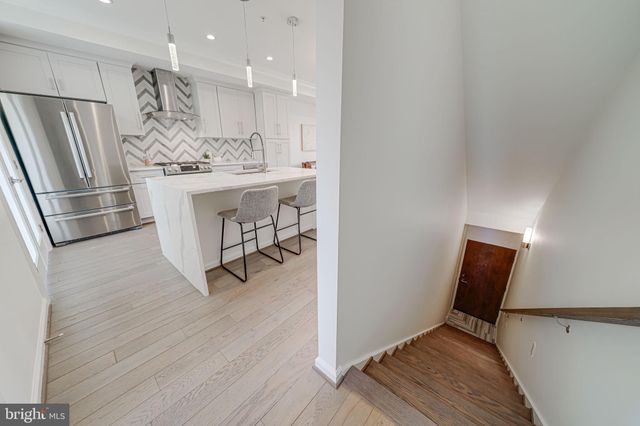 a room with stainless steel appliances kitchen island granite countertop furniture and a large window