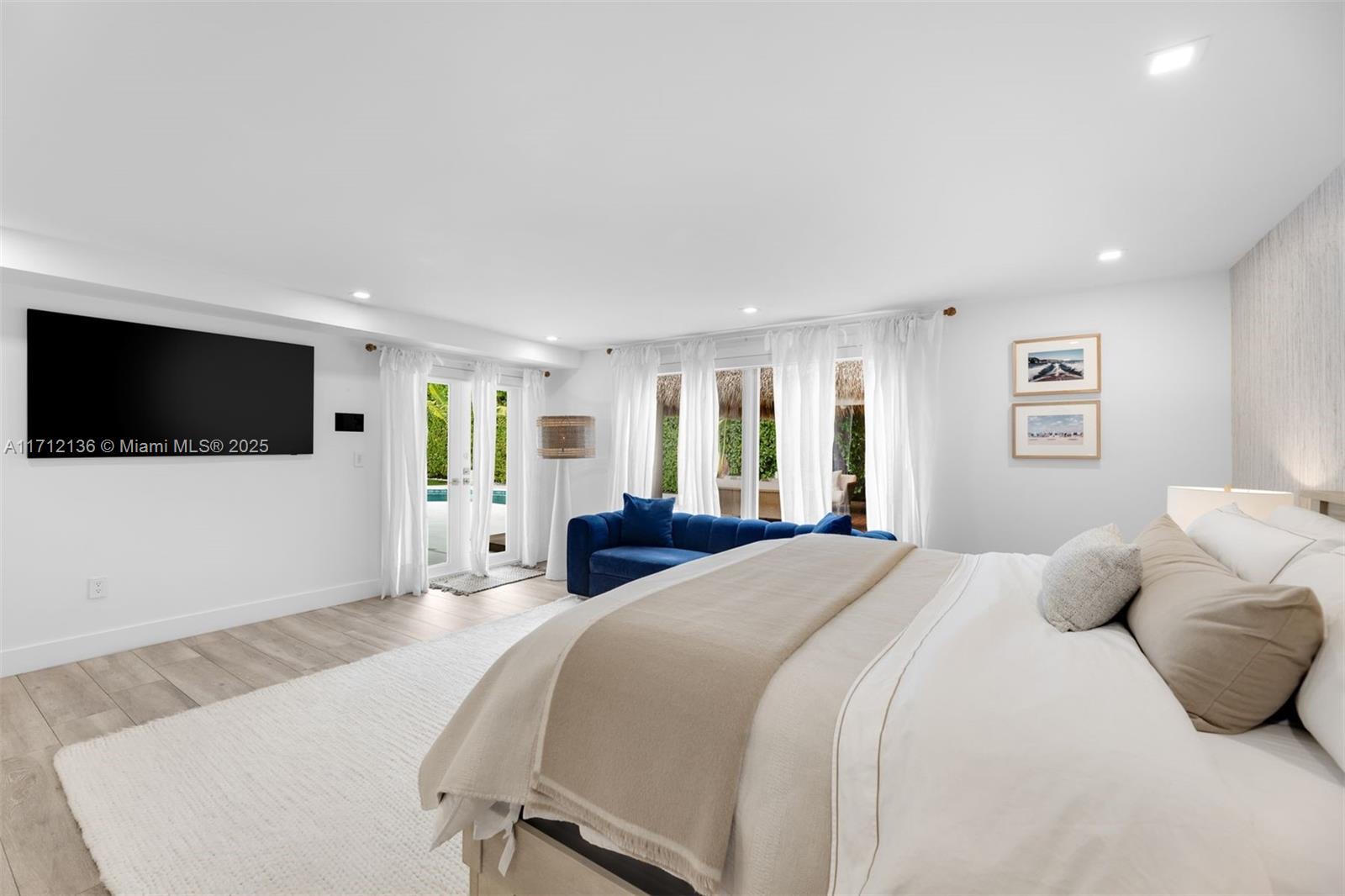 345 Gulf Road Key Biscayne, FL 33149 - Photo 18 of 43 a spacious bedroom with a bed and a flat screen tv