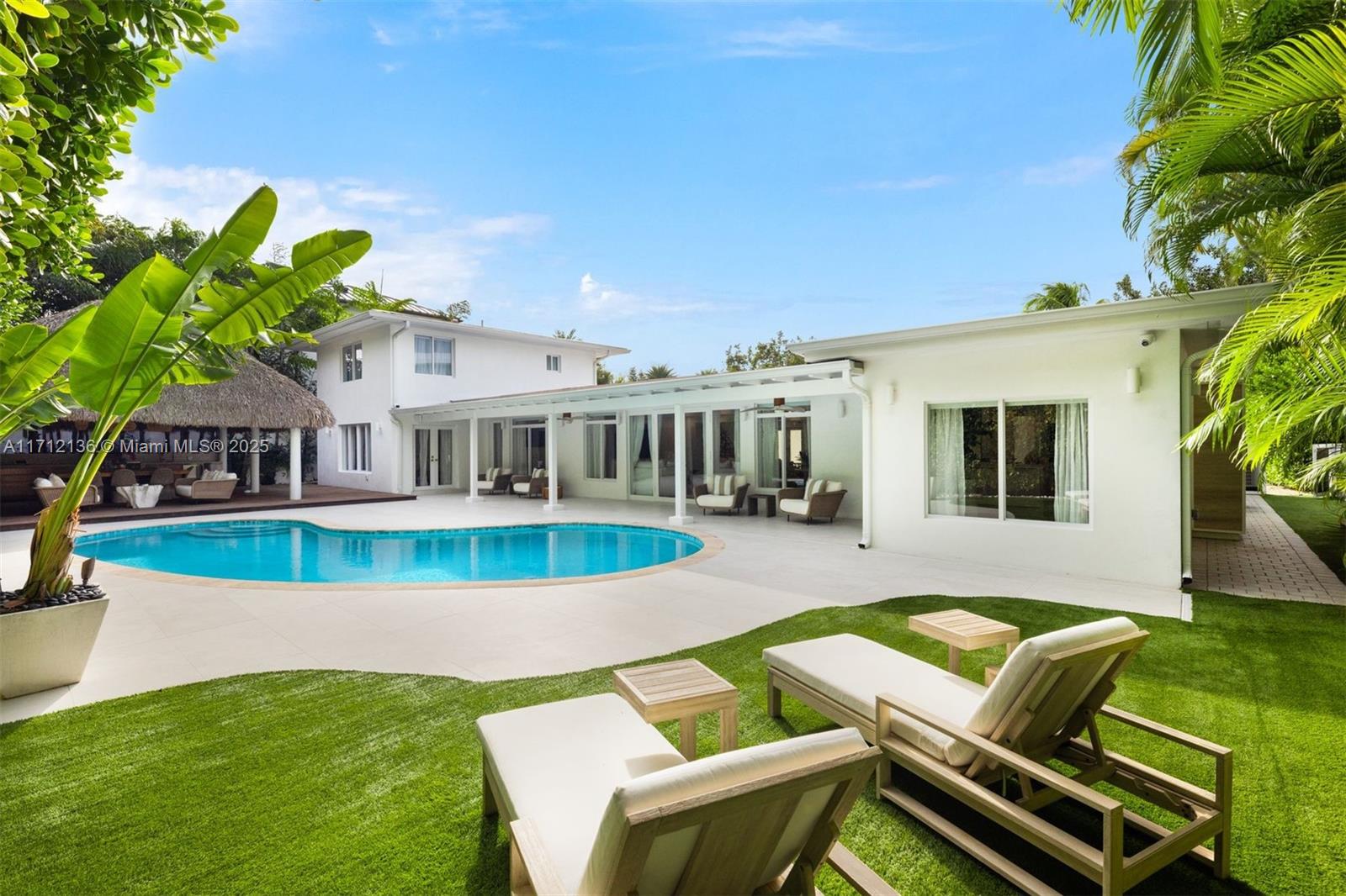 345 Gulf Road Key Biscayne, FL 33149 - Photo 37 of 43 a view of a house with pool fire pit a table and chairs