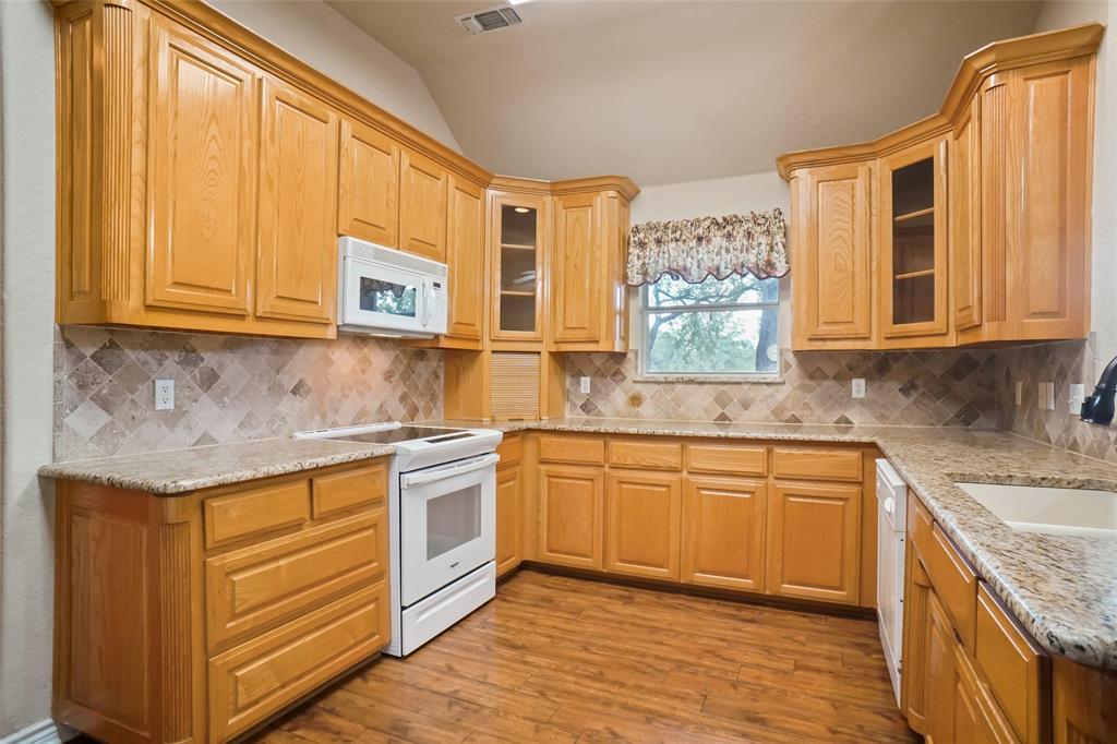 424 Half Moon Way Runaway Bay, TX 76426 - Photo 7 of 21 a kitchen with stainless steel appliances granite countertop a sink stove and cabinets