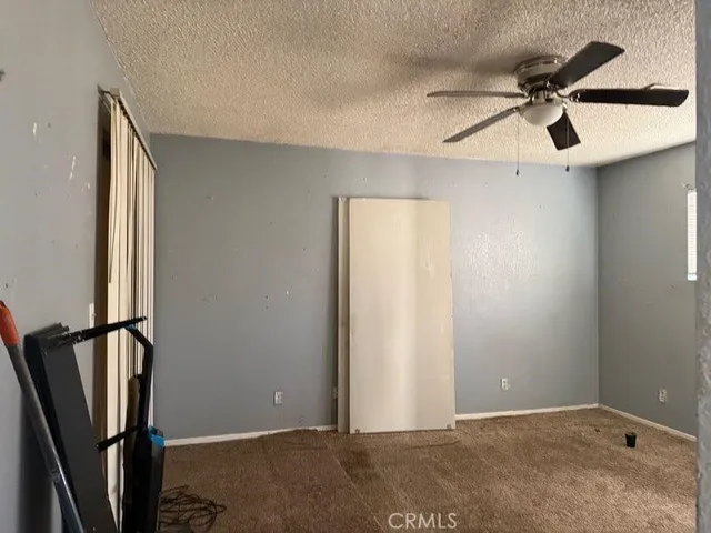 an empty room with wooden floor and a ceiling fan