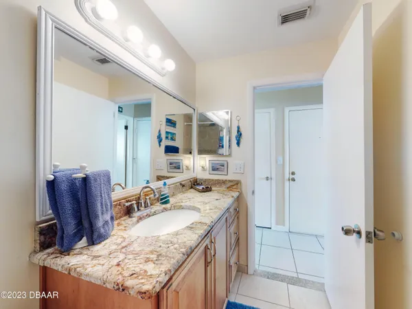 a bathroom with a granite countertop sink and a mirror