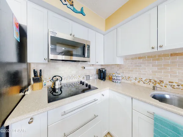 a kitchen with a sink a stove and cabinets