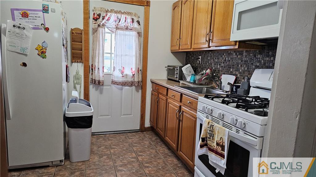662 Jacques Street Perth Amboy, NJ 08861 - Photo 5 of 11 a kitchen with a stove and a refrigerator