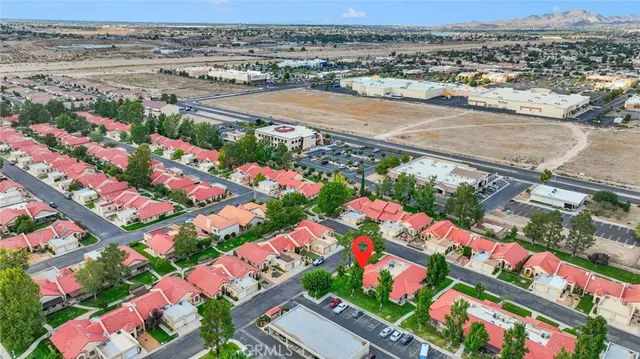 an aerial view of a city with lots of residential buildings ocean and mountain view in back