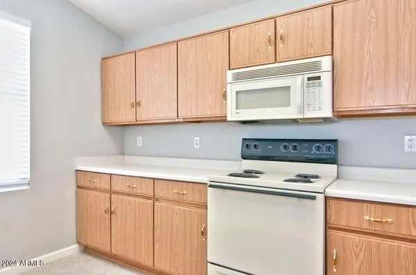 a kitchen with granite countertop white cabinets and white appliances