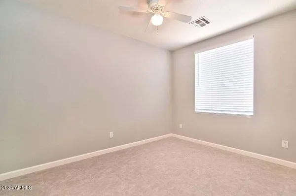 an empty room with a window and a fan