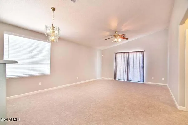 a view of a room with a ceiling fan and window