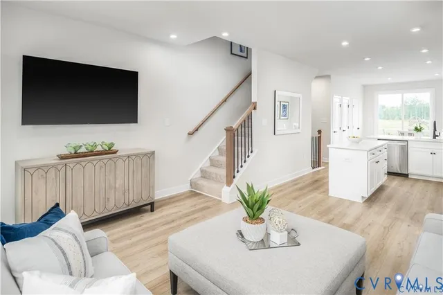 a living room with furniture kitchen view and a flat screen tv