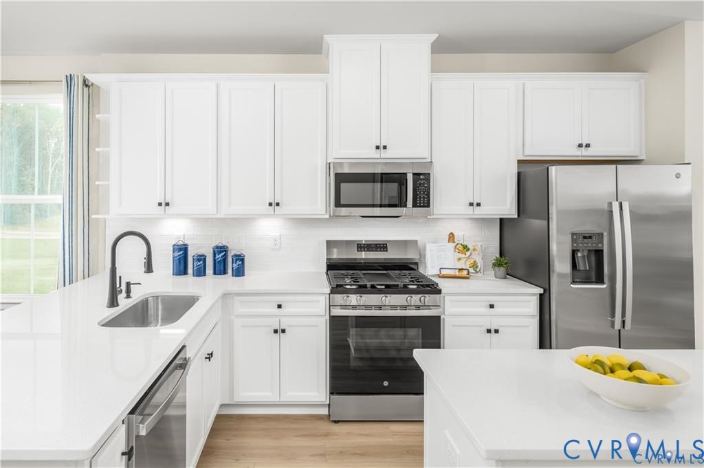 4719 Cloverleigh Drive Midlothian, VA 23112 - Photo 8 of 24 a kitchen with stainless steel appliances granite countertop a sink a stove a refrigerator and white cabinets