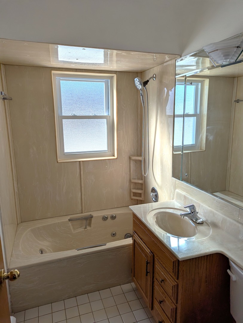 21-w139 Tee Lane Lane, Unit 2 Itasca, IL 60143 - Photo 4 of 9 a bathroom with a tub sink and mirror
