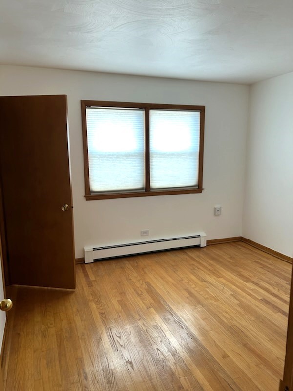 21-w139 Tee Lane Lane, Unit 2 Itasca, IL 60143 - Photo 5 of 9 an empty room with wooden floor and windows
