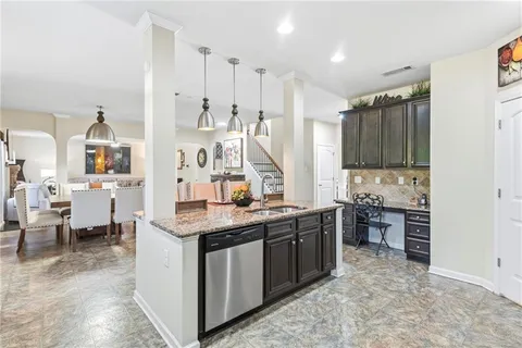 a kitchen with stainless steel appliances kitchen island granite countertop a stove a sink dishwasher and a refrigerator with wooden floor