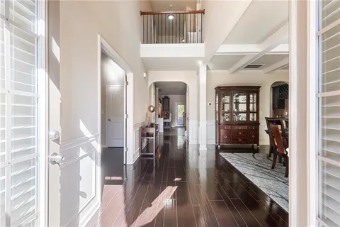 a view of a hallway with wooden floor and dining room