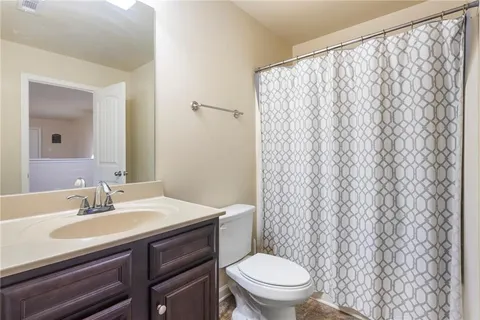 a bathroom with a sink a toilet and shower curtain