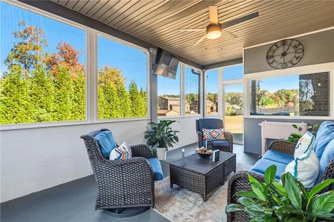 a living room with patio furniture and a potted plant