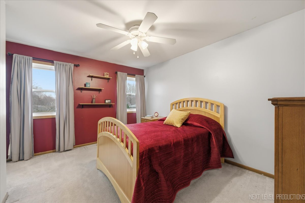 104 Augusta Road Oswego, IL 60543 - Photo 17 of 24 a bedroom with a bed and a chandelier