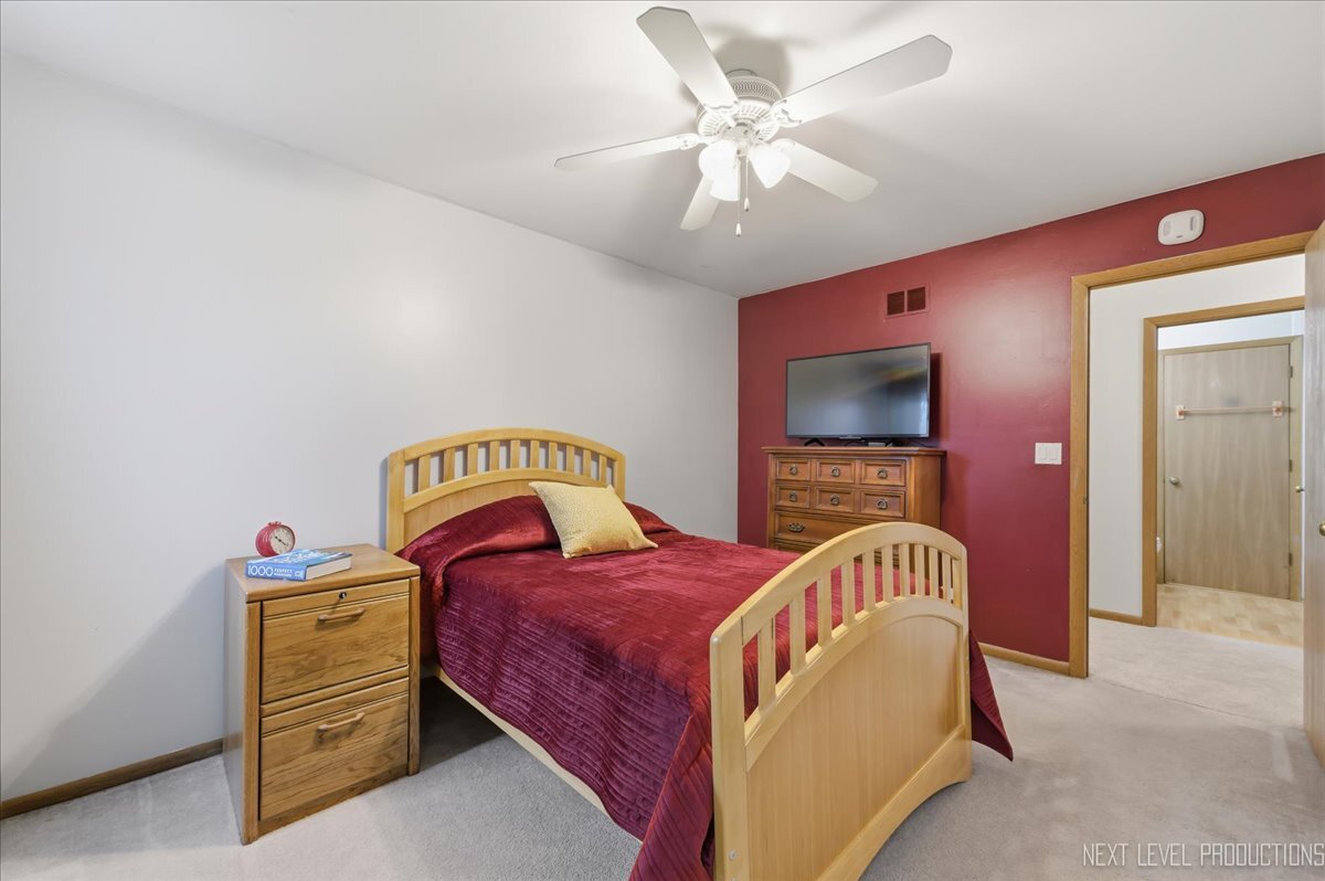 104 Augusta Road Oswego, IL 60543 - Photo 18 of 24 a bedroom with a bed and a chandelier