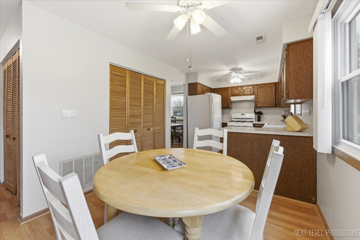 104 Augusta Road Oswego, IL 60543 - Photo 8 of 24 a kitchen with stainless steel appliances a dining table chairs and chandelier