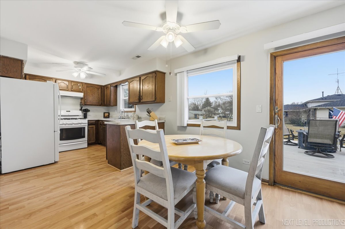 104 Augusta Road Oswego, IL 60543 - Photo 10 of 24 a kitchen with stainless steel appliances kitchen island granite countertop a stove a refrigerator a kitchen island a dining table and chairs with wooden floor