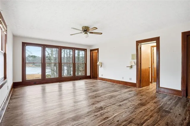 a view of a hallway with wooden floor and staircase