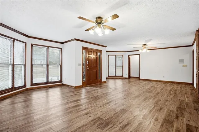 a view of an empty room with window and wooden floor