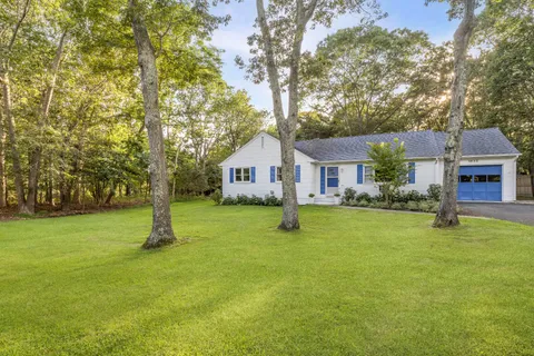 a front view of house with a garden and deck