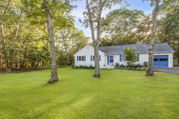 a front view of house with a garden and deck