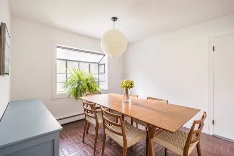 a view of a dining room with furniture and a potted plant