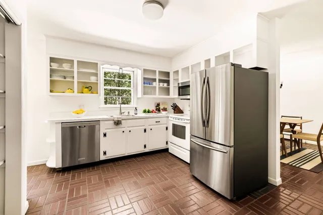 a kitchen with a refrigerator a stove a sink and a cabinets