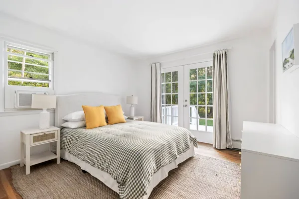 a bedroom with a bed and a large window