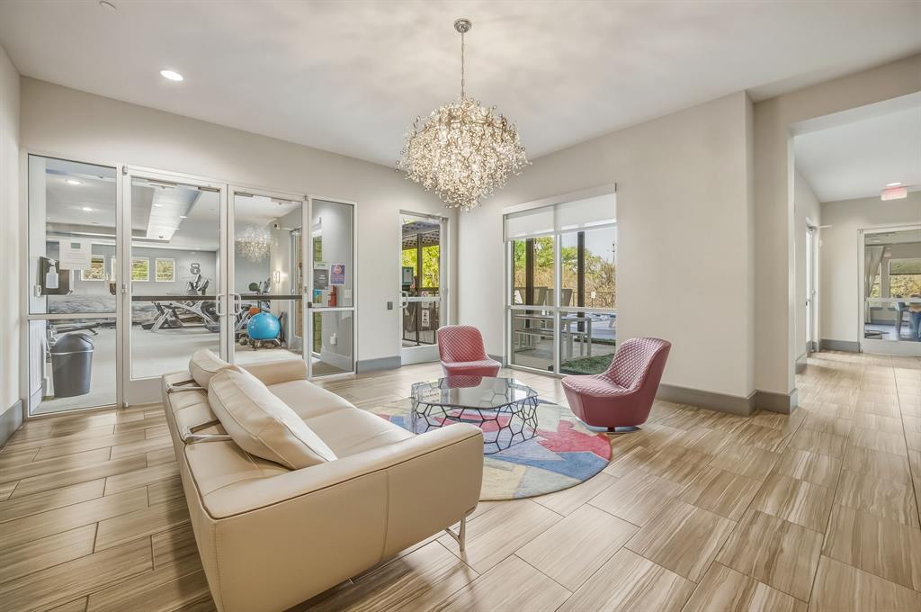 1900 Barton Springs Road, Unit 3040 Austin, TX 78704 - Photo 26 of 38 Spacious common area featuring wood-finish flooring and a prominent multi-tiered crystal chandelier