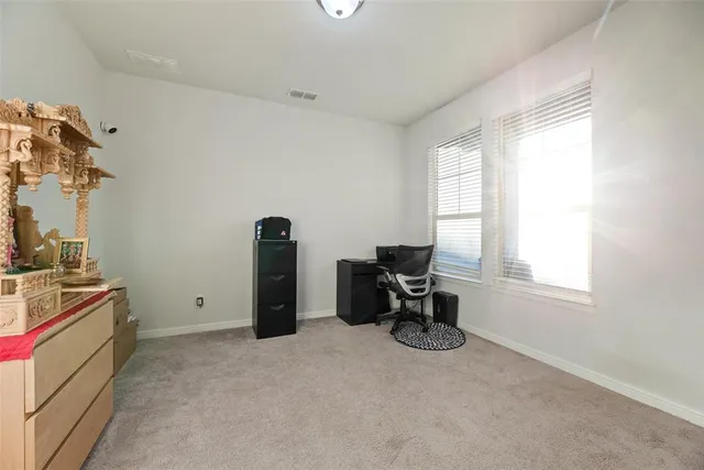 a view of a workspace with furniture and a window